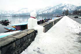 A snowman rests on the parapet of boulevard in Srinagar on Thursday