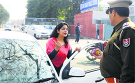 A woman asks a policeman to speak with an influential person on her phone in Ludhiana on Thursday.