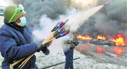 A protester aims fireworks at the police during clashes in Kiev on Thursday. AP/PTI