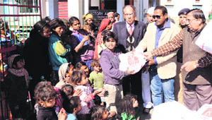 Dehradun District Magistrate BVRC Purushottam distributes blankets to poor children in Dehradun on Friday.