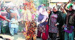 Members of Istri Jagriti Manch burn an effigy of Bikramjit Singh Majithia in Jalandhar on Friday