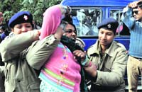 The police take away a protester in Dehradun on Saturday