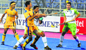 Jamie Dwyer (centre) vies for the ball during the first HIL match in Mohali on Saturday.