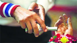 An anti-government protester pours water over the hand of killed protest leader Suthin Tharatin during his funeral ceremony at a temple in Bangkok on Monday.