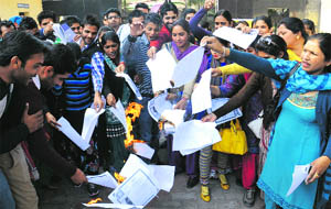 Guest faculty lecturers burn copies of their degrees to mark their protest against the state government in Bathinda on Tuesday.