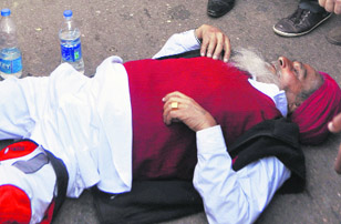 Senior citizen Gurnam Singh lies on the road.