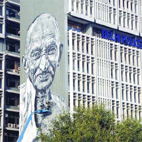 The portrait of Mahatma Gandhi being erected on the wall of the Delhi Police headquarters in New Delhi on Tuesday