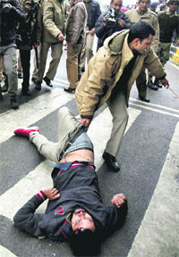 A policeman drags an AAP worker during the partys dharna near Rail Bhavan, New Delhi. Functioning as a de-facto Central force, the Delhi Police are devoid of intimate people-connect and effective oversight mechanisms which are the essential hallmarks of a democratic system. pti