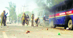 A police bus set ablaze by protesters during a clash with the police on the outskirts of Hisar on Tuesday. Photo: Banshi Lal Basniwal
