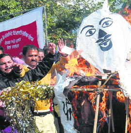 Members of the Punjab and UT Mulazam Sangharsh Committee burn an effigy of the state government in Jalandhar on Tuesday.