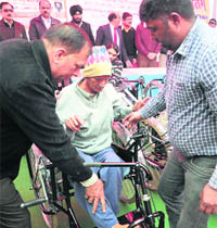 Members of Bharat Vikas Parishad distribute hearing aids, tricycles, crutches, wheelchair and artificial limbs to differently-abled persons in Jalandhar on Tuesday.