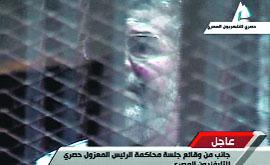 Egypts toppled President Mohammed Morsi stands inside a glass-encased metal cage in Cairo on Tuesday.