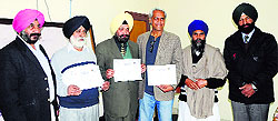 District Tourism Officer Balraj Singh (left) offers certificates to subscribers of Punjab governments Bed and Breakfast Scheme in Amritsar on Wednesday