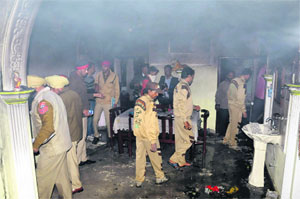 Police officials at a house in Baba Deep Singh Nagar where a woman was burnt to death in Bathinda on Wednesday.