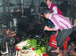 Workers salvage goods from a gutted room of the hotel at Zirakpur. Tribune photo