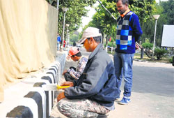 A labourer paints a road divider on the campus of the University of Jammu ahead of the 101st Indian Science Congress being held from February 3 to 7. Tribune photo: Anand Sharma