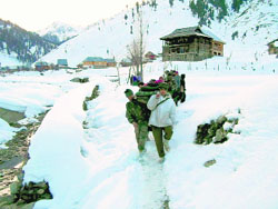 Army personnel carry a pregnant woman on a stretcher in Kupwara district.
