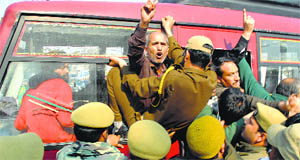 The police detain protesting government employees in Jammu on Thursday.