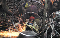 Workers at a bicycle parts unit in Ludhiana. Tribune photo