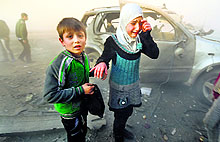 A girl cries near a damaged car at a site hit by barrel bombs allegedly dropped by government forces at Aleppo Dahret Awwad in Syria on Thursday