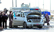 Police dismantle a car bomb outside a government building that was stormed by attackers on Thursday in Baghdad