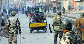 Youths throw stones at security forces personnel during a protest against closure of Pathribal case by the Army, in Srinagar on Friday.