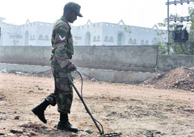 An Army personnel conducts a security check at the University of Jammu. 