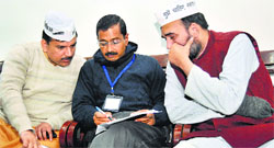 Delhi Chief Minister Arvind Kejriwal flanked by AAP leaders Sanjay Singh (L) Gopal Rai in New Delhi on Friday. A Tribune photograph