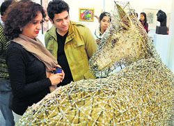 Visitors look at an artwork at the India Art Fair in New Delhi on Friday. Tribune photo: Manas Ranjan Bhui