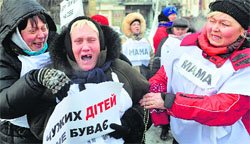 A woman, whose one son was killed and another is missing, cries during a rally in Kiev on Friday. AFP