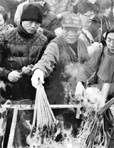 People light incense sticks to pray at the Yonghegong Lama temple in Beijing during the celebrations of the Lunar New Year on Saturday.