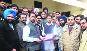 A delegation of teachers hands over a memorandum to Cabinet Minister Anil Joshi in Amritsar on Sunday.