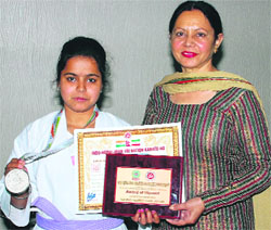 Navneet shows her silver medal and certificates that she won in the karate championship in Amritsar.
