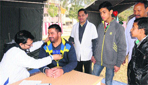 A doctor examines patients at a medical camp organised on the occasion of the 45th Raising Day of the 51st Battalion of the Central Reserve Police Force on Sunday. 