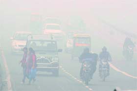 Commuters drive in the foggy morning in New Delhi on Sunday