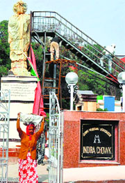 Labourers install a statue of former Prime Minister Indira Gandhi at Indira Chowk in Jammu.