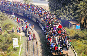 Commuters ride on the roof of a train as they return to the city after attending the Akheri Munajat (final prayers) in Dhaka on Sunday.