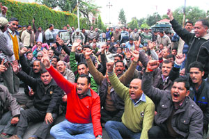 Revenue officials stage a dharna in Dehradun on Monday.