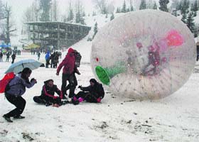 Tourists enjoy a ride on zorbing in the Solang valley on Monday