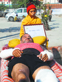 Ashok Kumar at civil hospital as his wife shows his bravery award certificate in Ambala