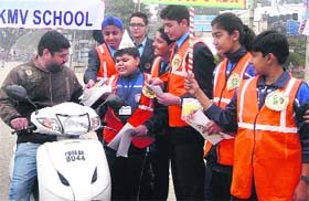Students of Sanskrit KMV School distribute pamphlets containing traffic rules in Jalandhar on Monday