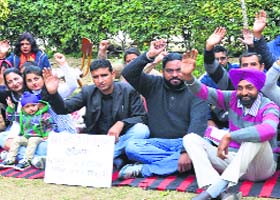 Members of the AIDS Control Employees Welfare Association shout slogans in Ludhiana on Monday