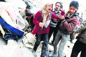People rescue a girl buried under debris after explosives were allegedly thrown by Syrian forces in Aleppo on Monday.