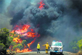 Firefighters try to contain a bushfire in Banjup, a suburb of Perth, Western Australia, on Monday. A bushfire continues to burn out of control, threatening lives and homes in Perth's southern suburbs.