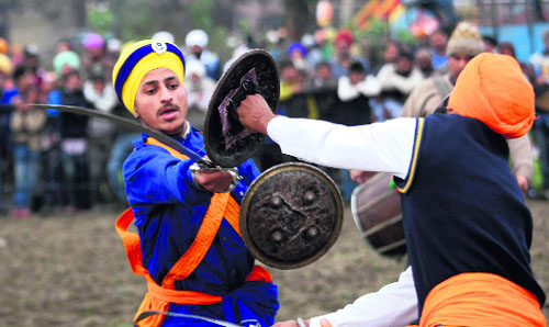 Sikh boys display gatka skills during a fair held on the occasion of Basant Panchami at Cheharta near Amritsar on Tuesday