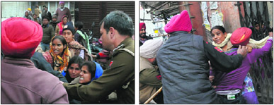 Policemen drag away the agitating teachers from Subhash Market on the Mall Road in Bathinda on Tuesday.