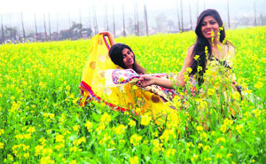 Two young girls in a mustard field on the occasion of Basant Panchami near Dehradun on Tuesday.