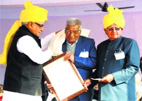 Chief Minister Bhupinder Singh Hooda honours a senior citizen on Sir Chhotu Ram Jayanti in Rohtak on Tuesday