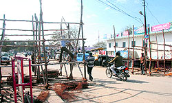 Workers put up wodden barricades on the road towards the state Assembly on the eve of the budget session in Dehradun on Wednesday