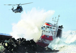 A military helicopter flies over a Spanish cargo ship Luno that slammed into a jetty in the choppy Atlantic waters and broke into two, off Anglet, France, on Wednesday. 